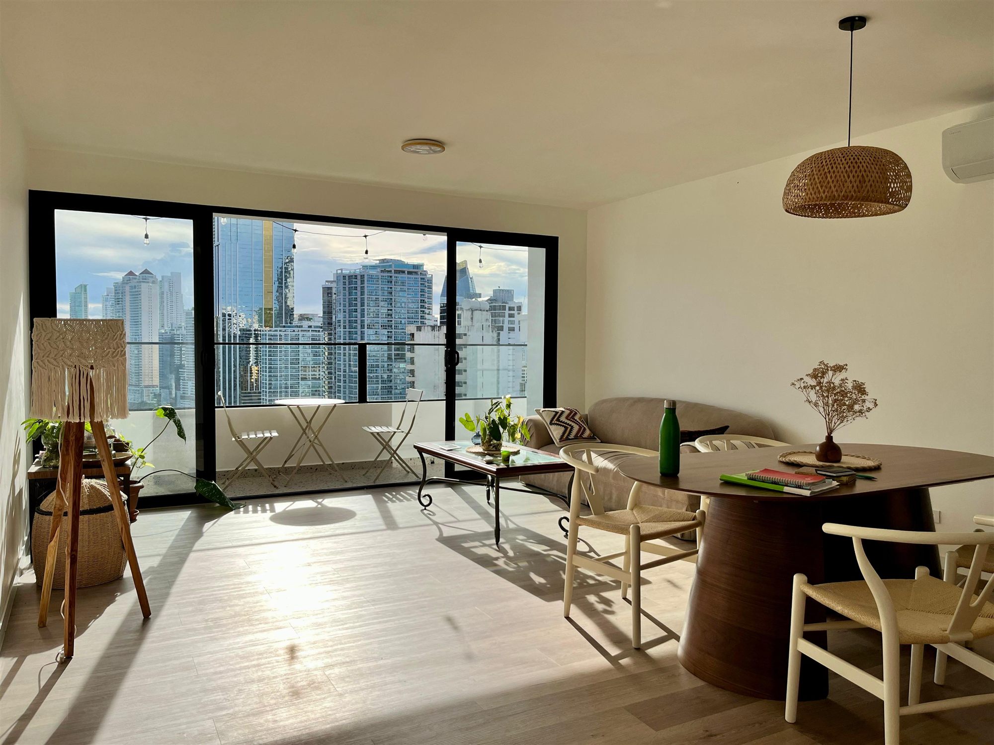Sala de estar y comedor reformados por Re-Valora en Posada del Rey, Punta Paitilla, con vista al skyline de Ciudad de Panamá.